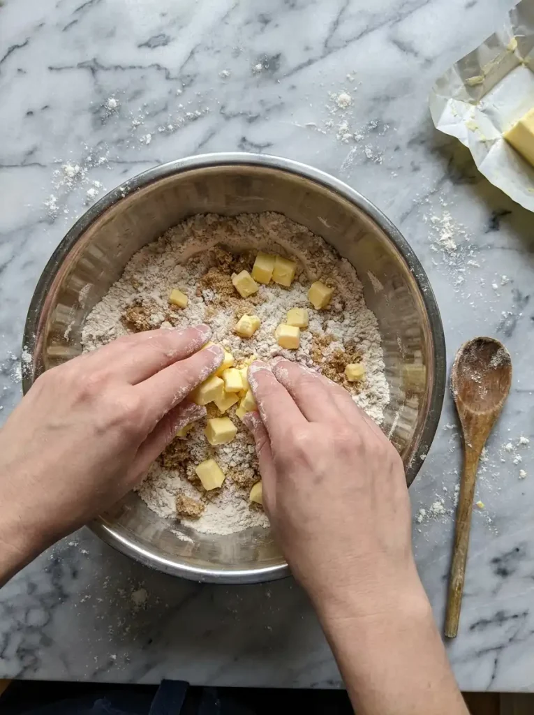 Rubbing cold butter into flour and brown sugar to make the oat-free apple crisp topping